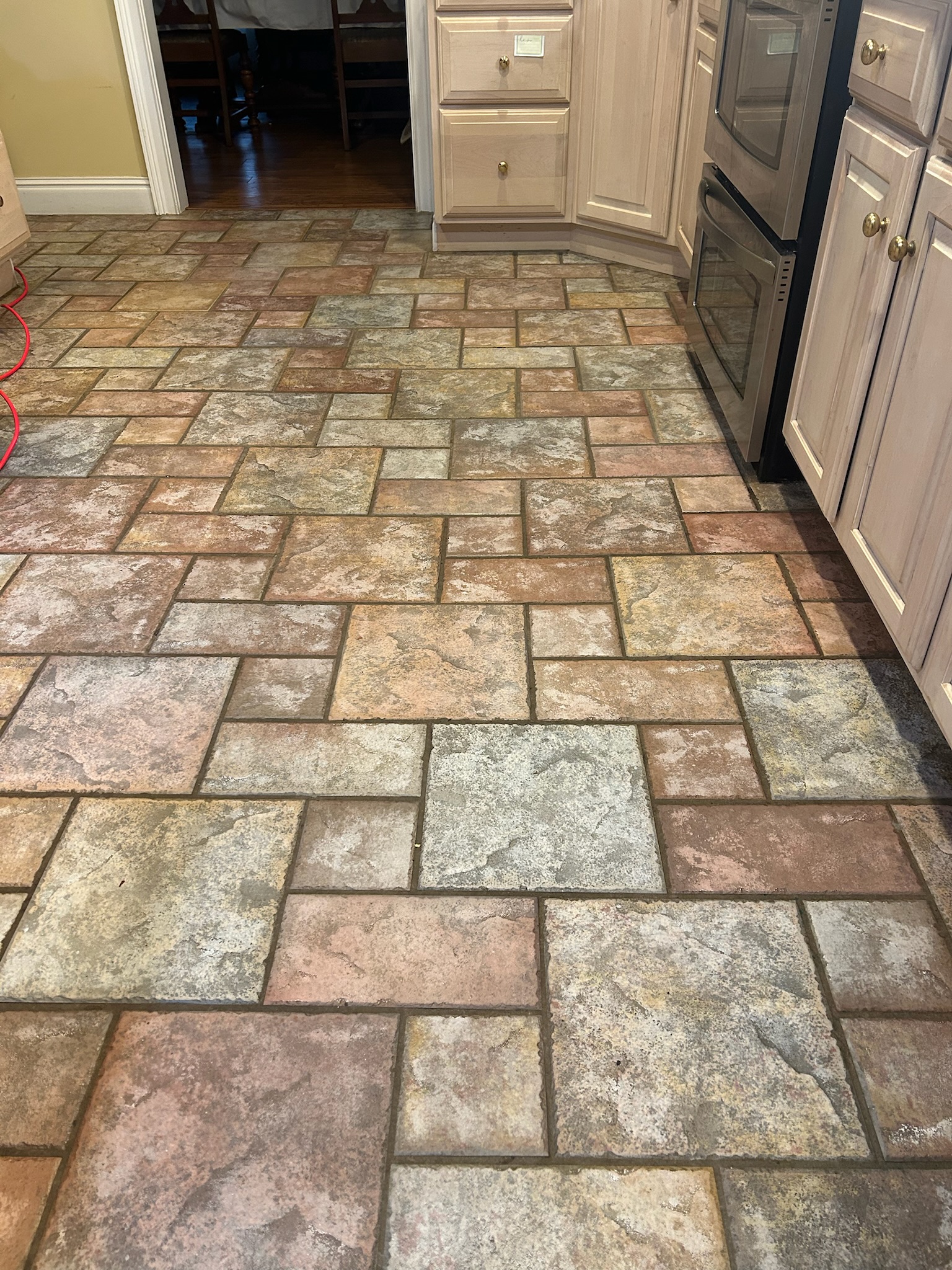 Kitchen floor with years of stained grout before cleaning