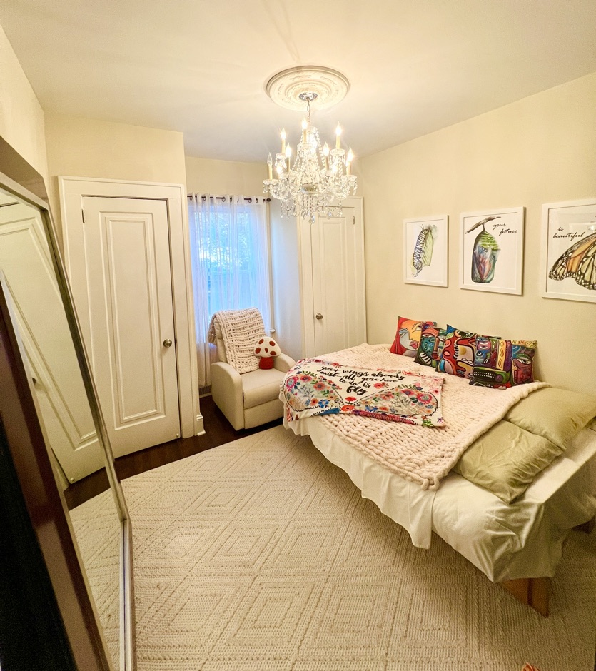 The Cocoon Room bedroom with chandelier and colorful accents