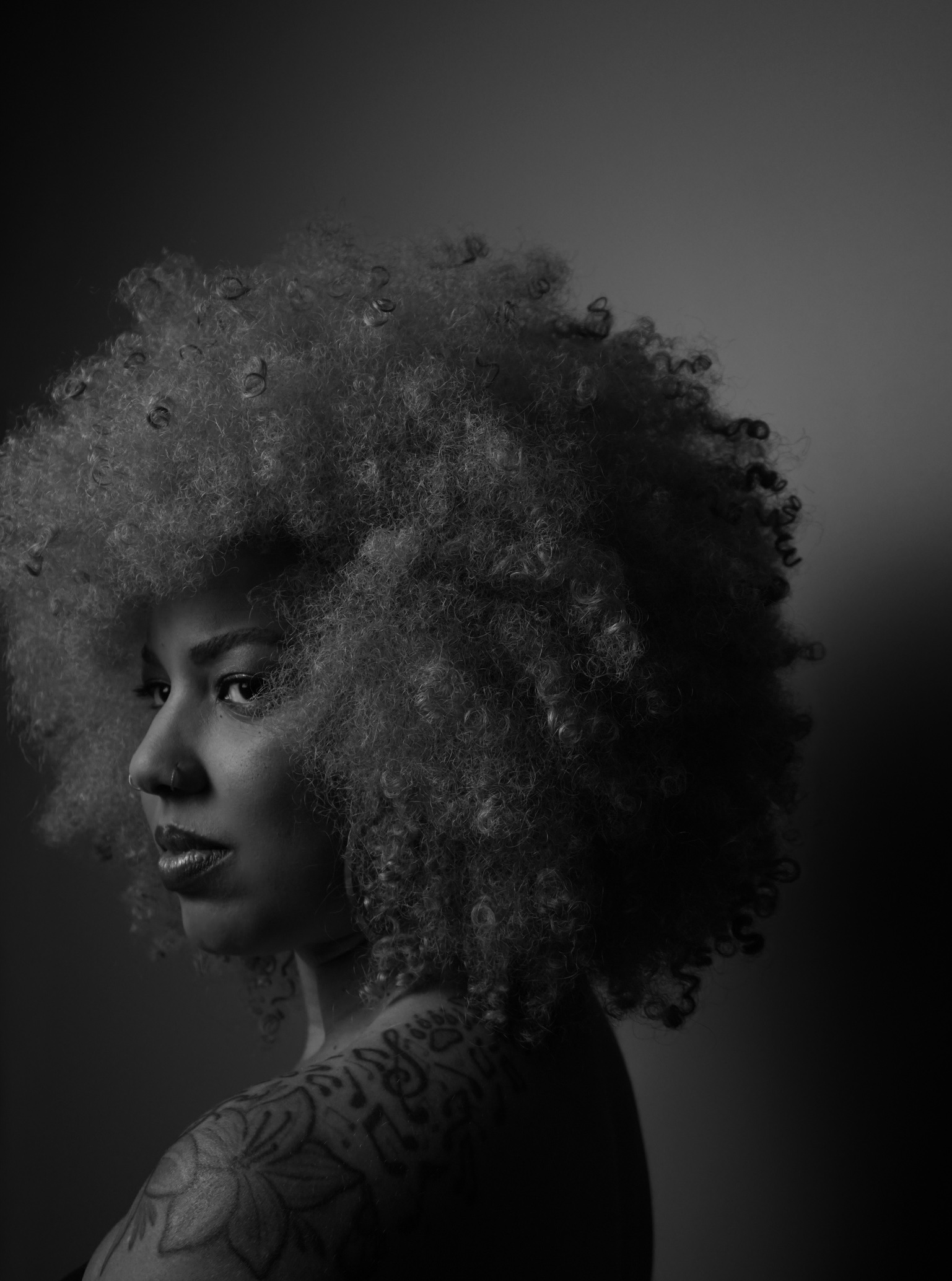 Full-bleed cinematic portrait closing the gallery, deep shadow and warm light