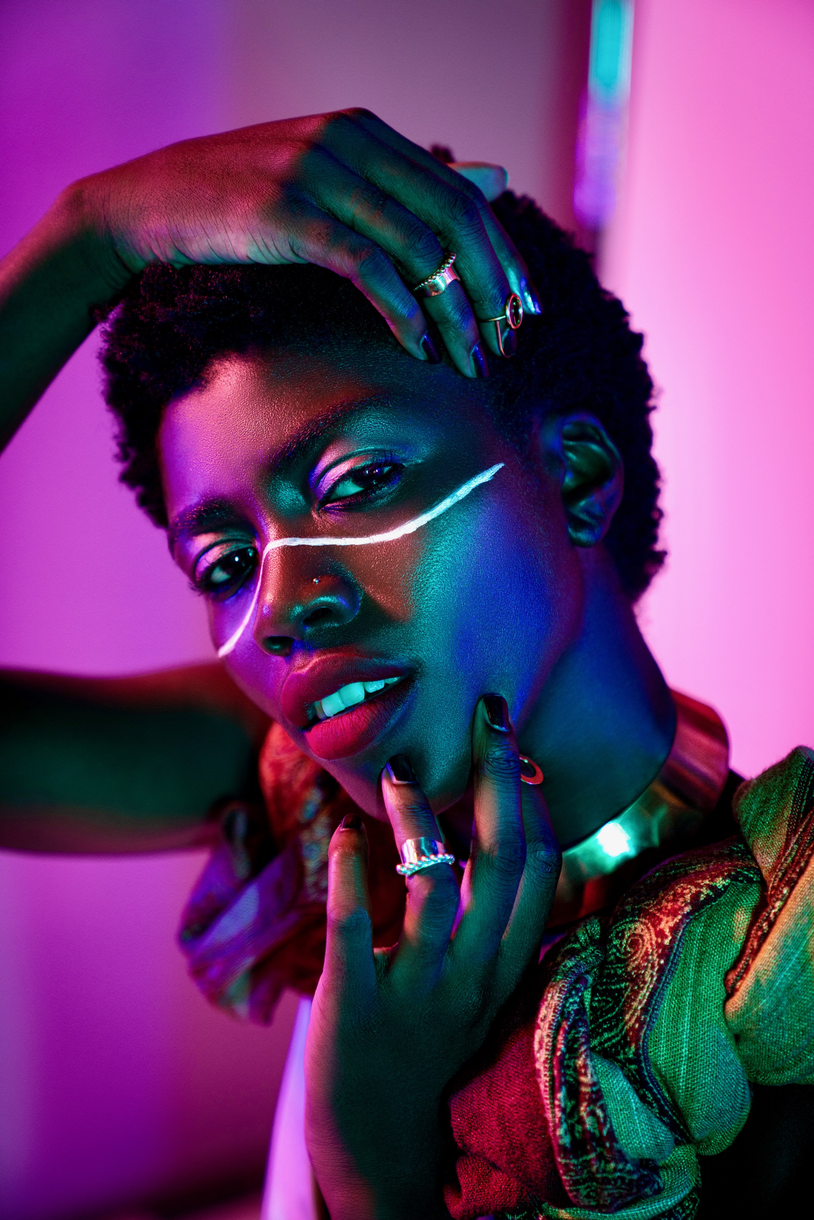Creative beauty portrait with neon pink lighting and graphic eye makeup
