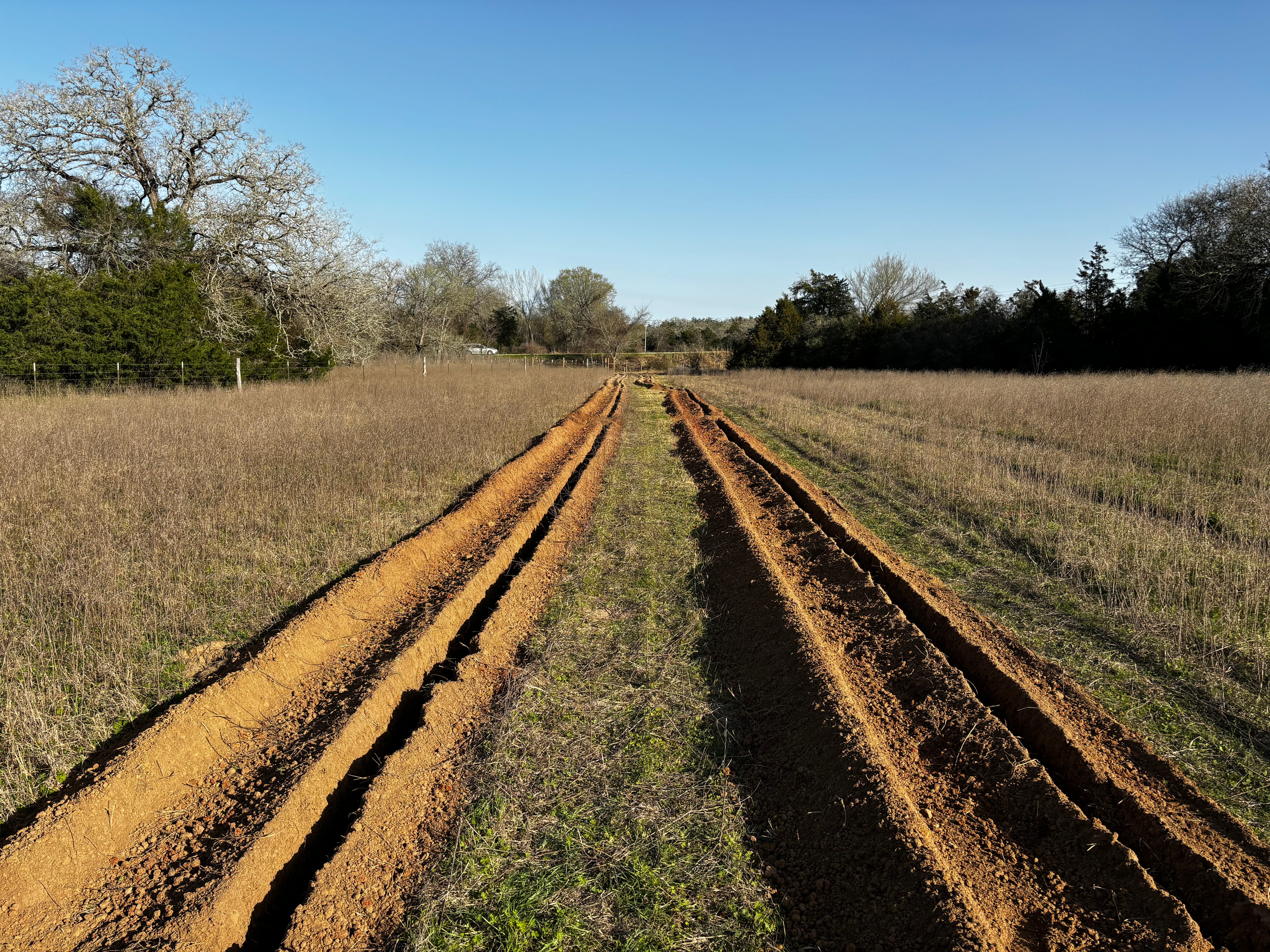 Excavator lifting concrete tank during excavation in Bastrop Texas