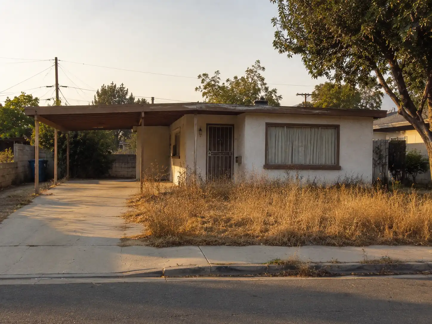 Older single-story bungalow with a chain-link fence in San Bernardino, CA
