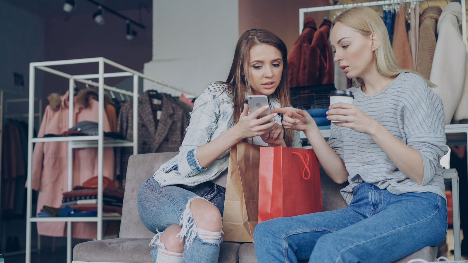 Shopper comparing holiday gift options on a smartphone while browsing in a retail aisle — comparison before committing to the trip. Shopper comparing holiday gift options on a smartphone while browsing in a retail aisle — comparison before committing to the trip.