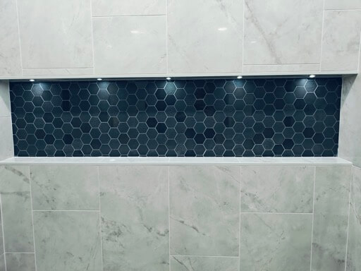 Full-length shower niche with a charcoal hex-mosaic back and integrated LED downlights