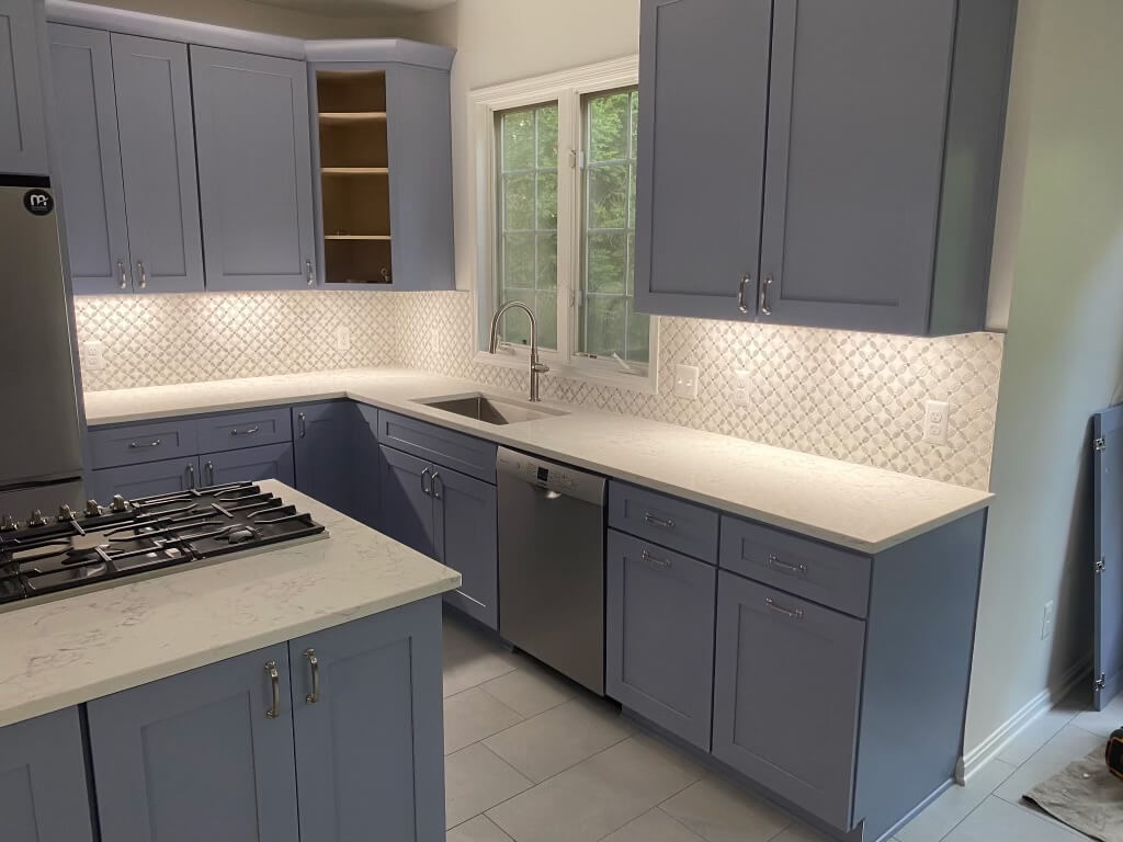 Finished kitchen remodel in Alexandria, VA, with slate blue-gray shaker cabinets, marble-look quartz counters, and an island gas cooktop