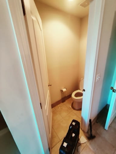 Before: the original water closet with an almond-colored toilet, beige walls, and dated beige floor tile