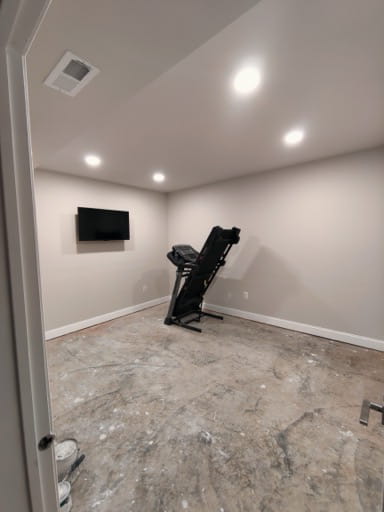 Finished basement exercise room in Prince William County with recessed lighting, a wall-mounted TV, and a treadmill