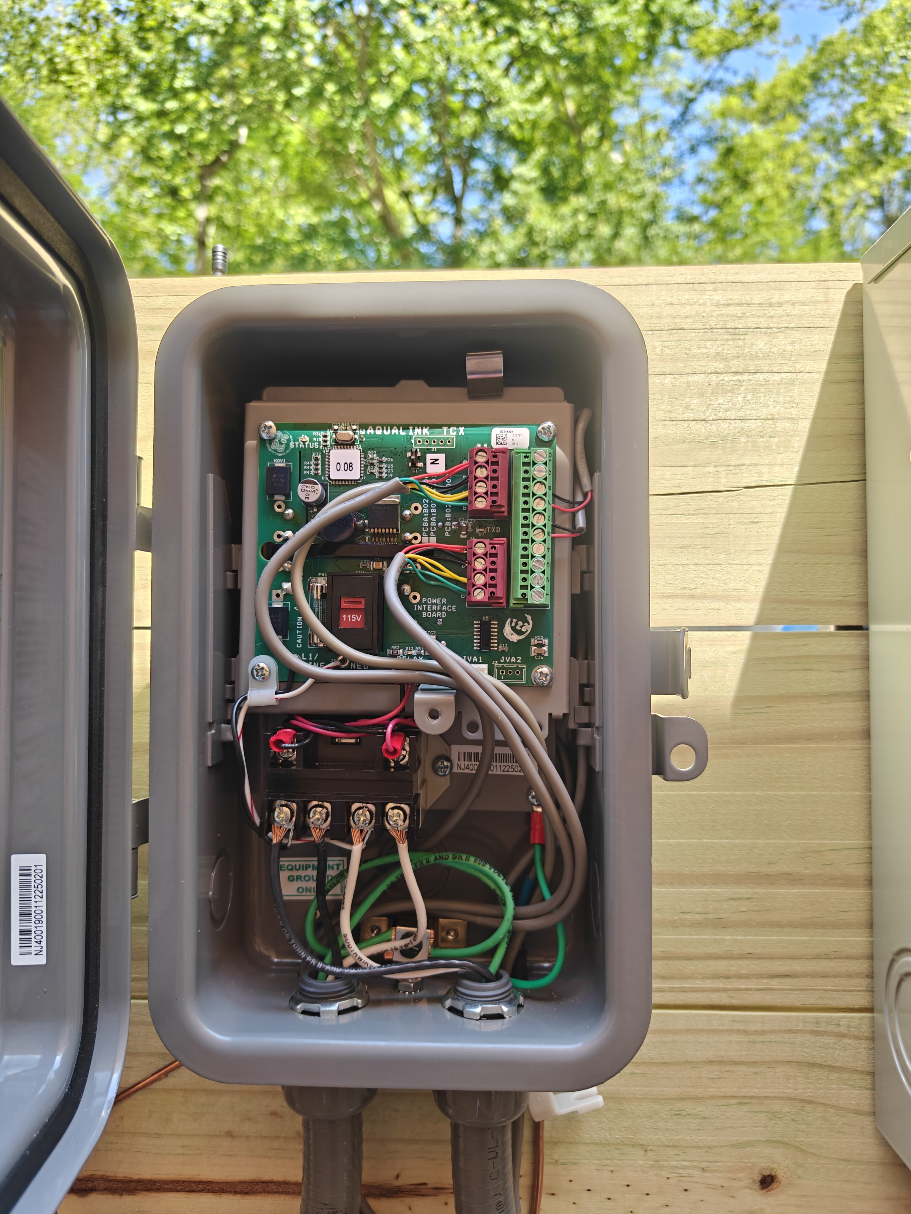 Open Jandy AquaLink pool automation panel, wired and terminated, mounted on the equipment rack