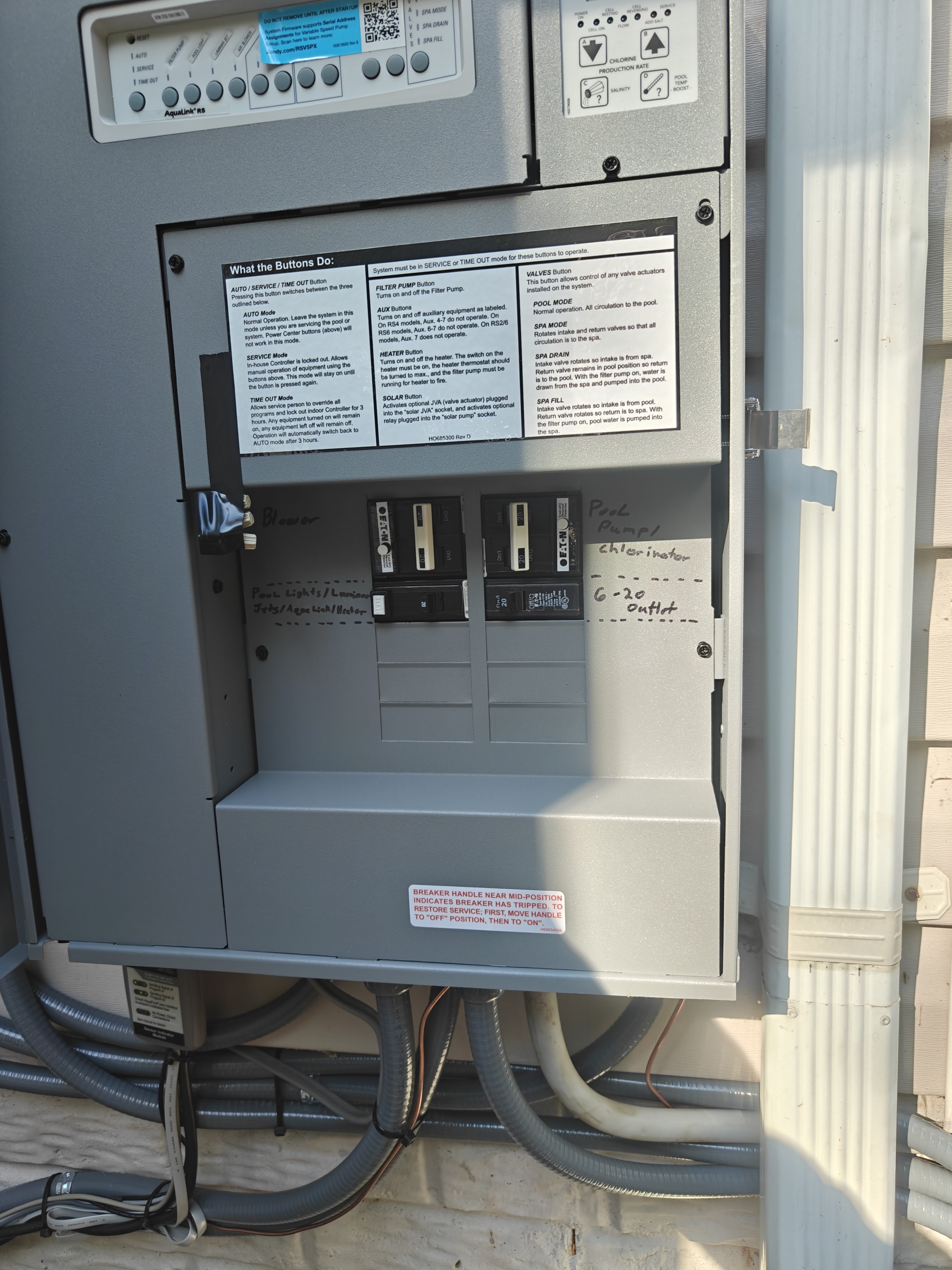 Open Jandy AquaLink RS pool panel with handwritten labels for the blower, pool lights, laminar jets, heater, pool pump, chlorinator, and 6-20 outlet