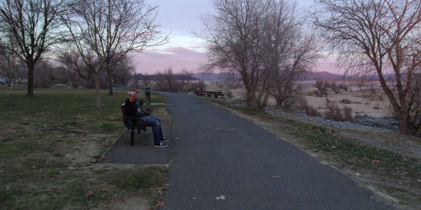A paved path and bench beside Folsom Lake at Beals Point