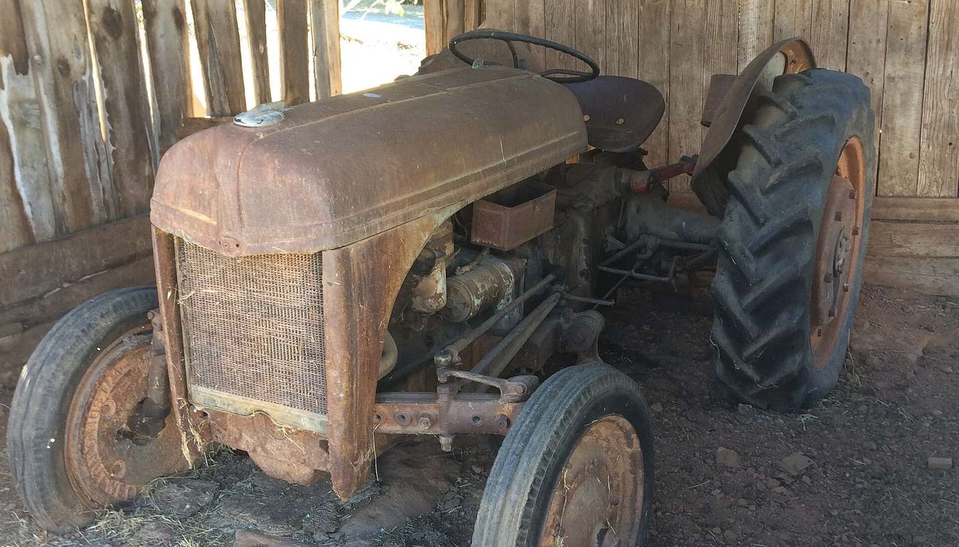 An old tractor in a wooden barn in Placerville
