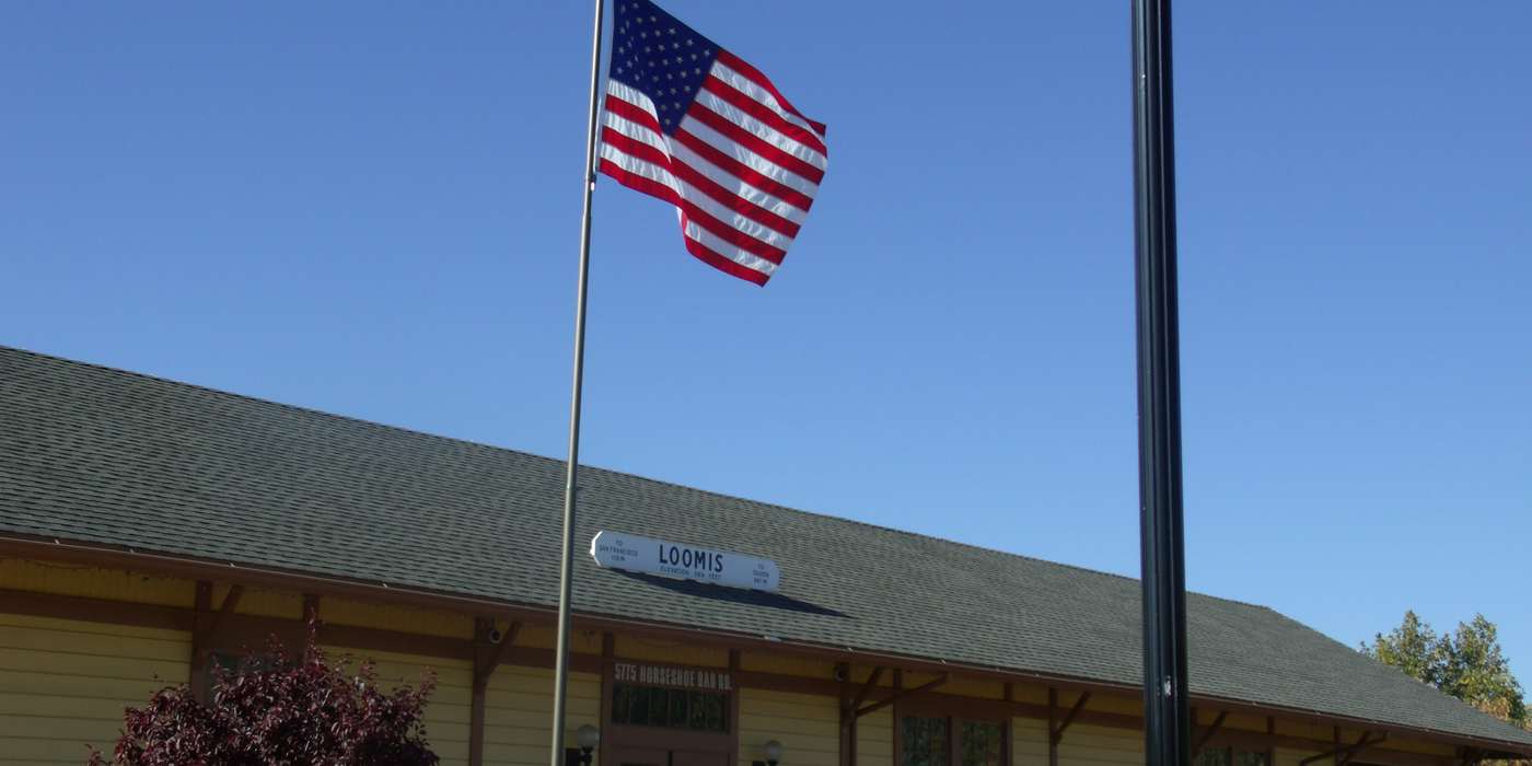 The historic Loomis train depot with an American flag