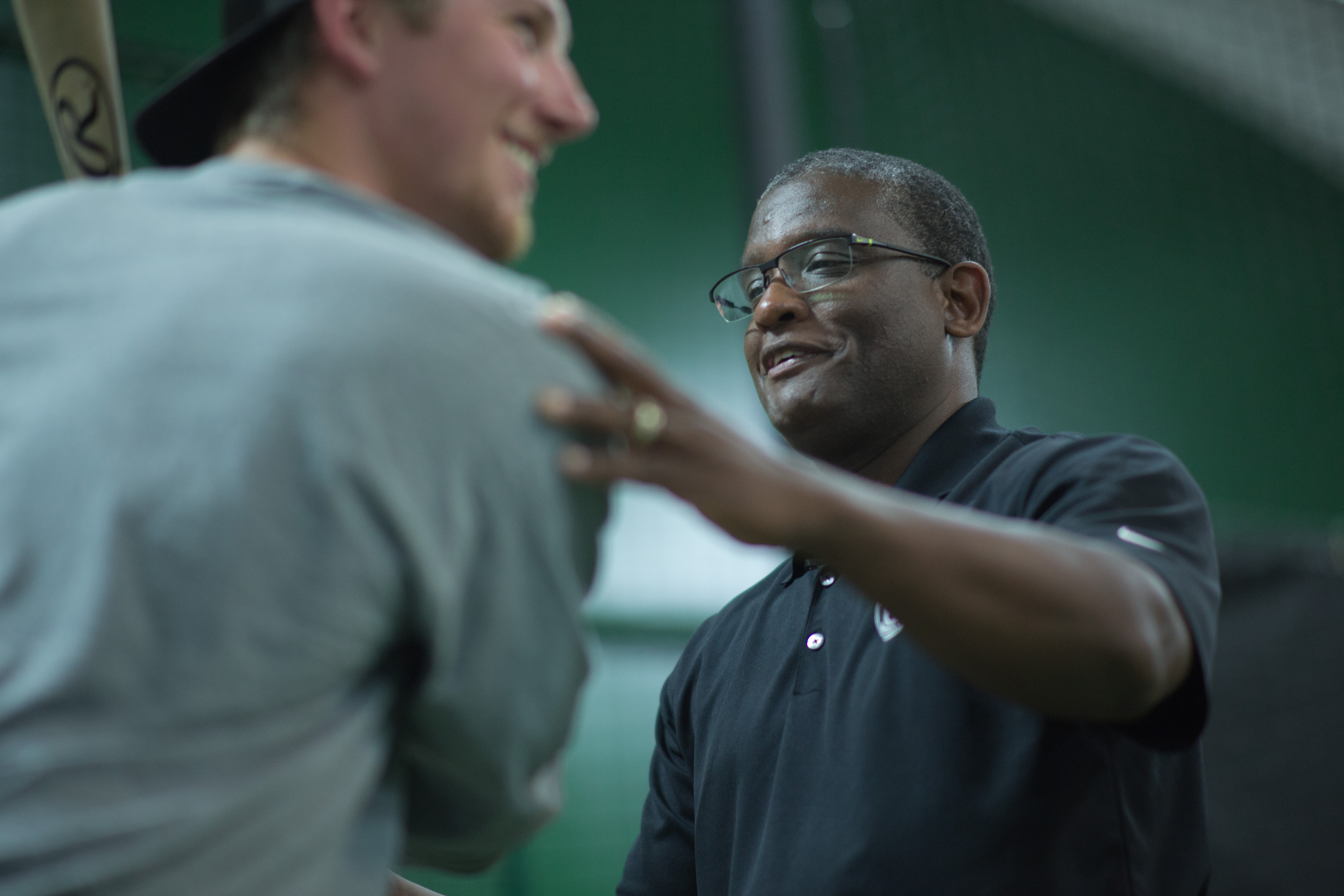 Coach Rick working with a baseball player during a hitting session