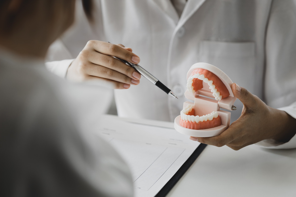 A One Dental clinician explaining a dental model to a patient