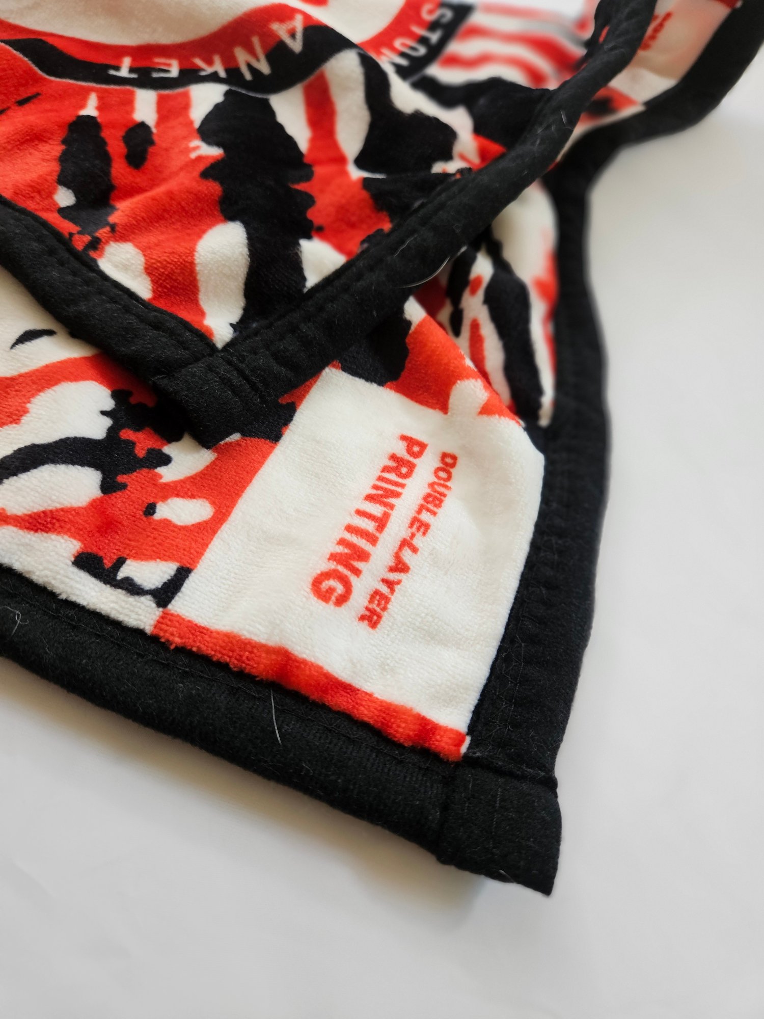 Red white and black patterned fabric merchandise with brand tag