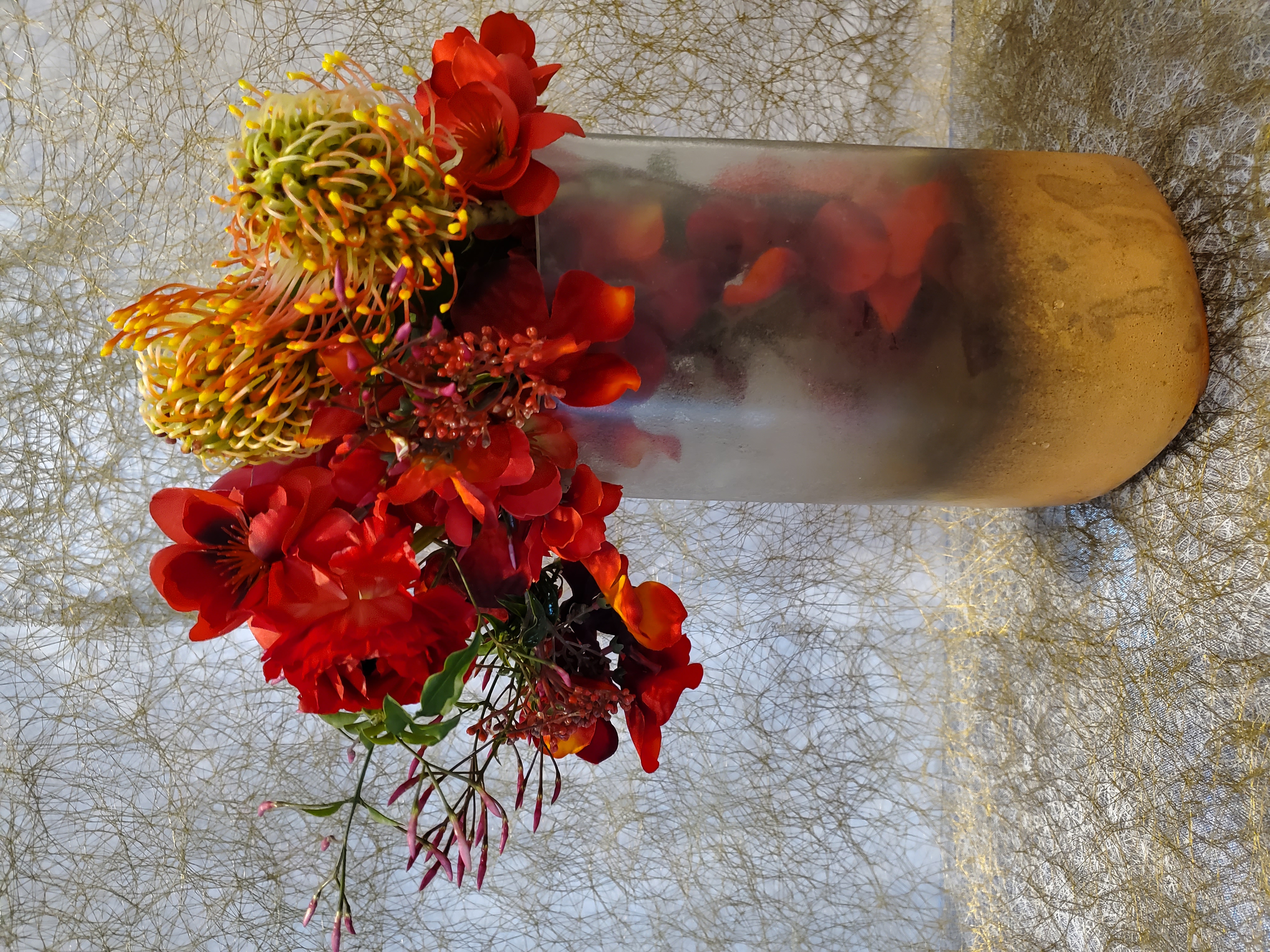 Red and yellow contemporary floral arrangement by Rikka Floral