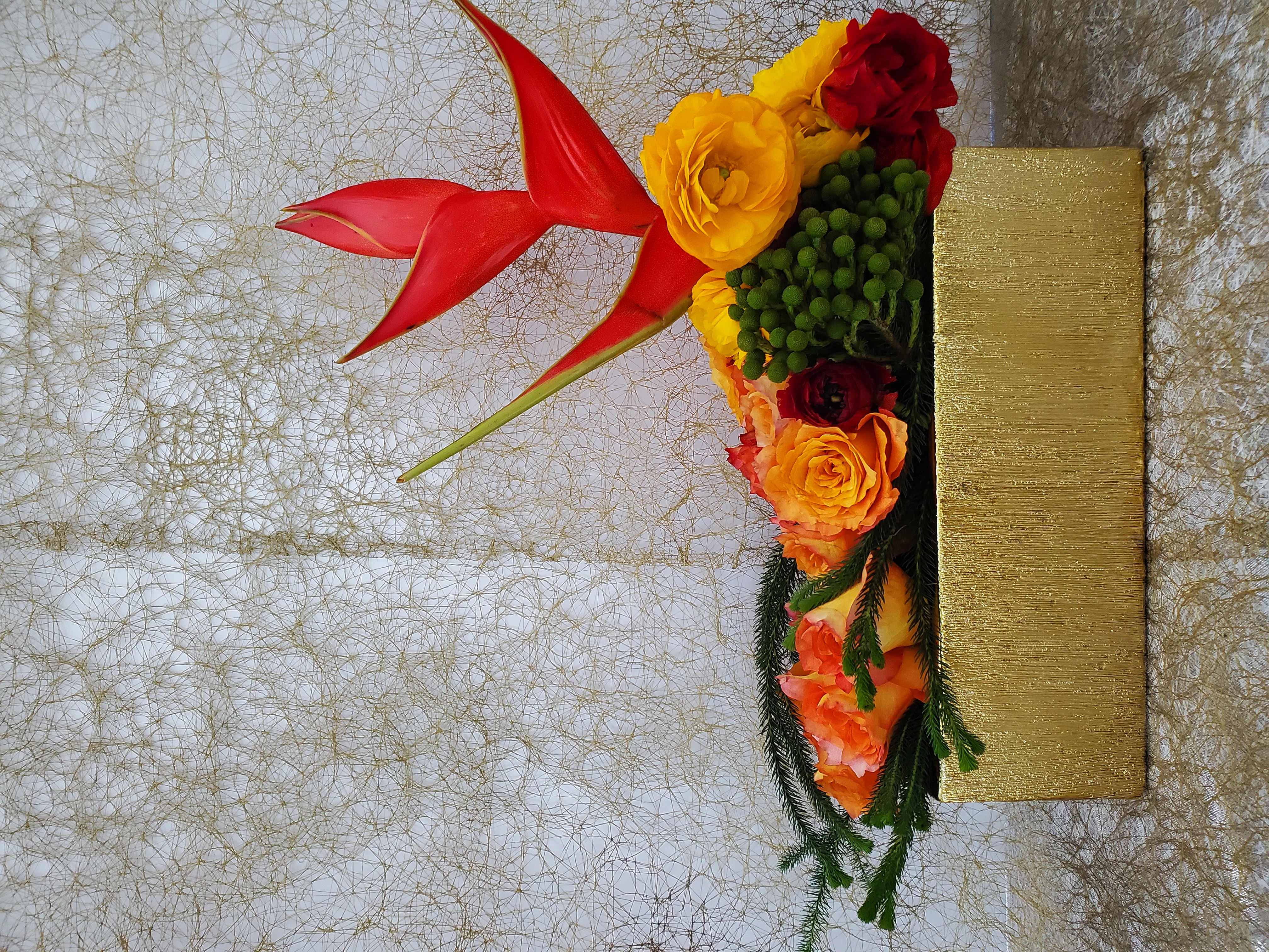 Red and orange artistic floral arrangement by Rikka Floral
