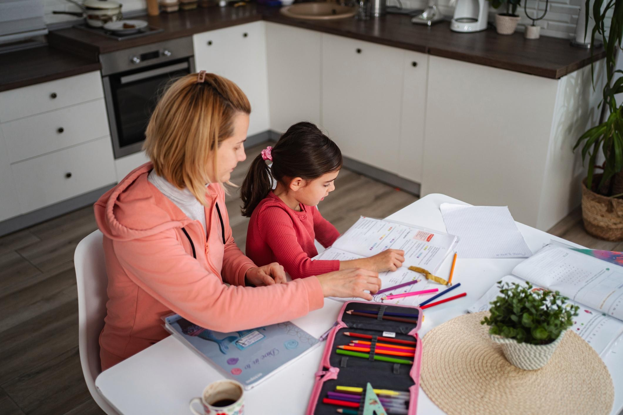 Parent and child doing a learning activity together at home during the back-to-school transition.