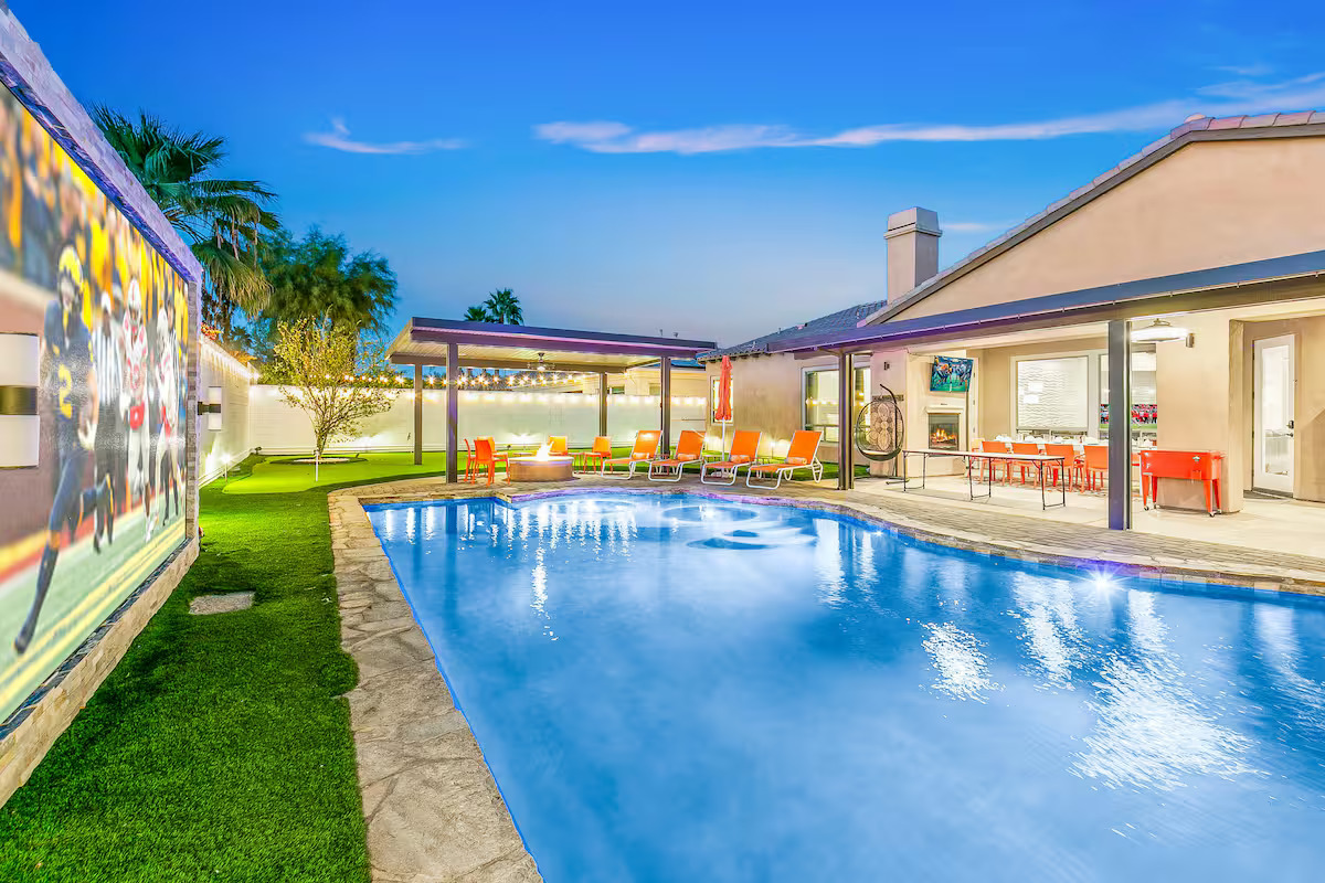 Poolside outdoor movie night at a Palm Springs Airbnb with a YOLO TV glowing at dusk