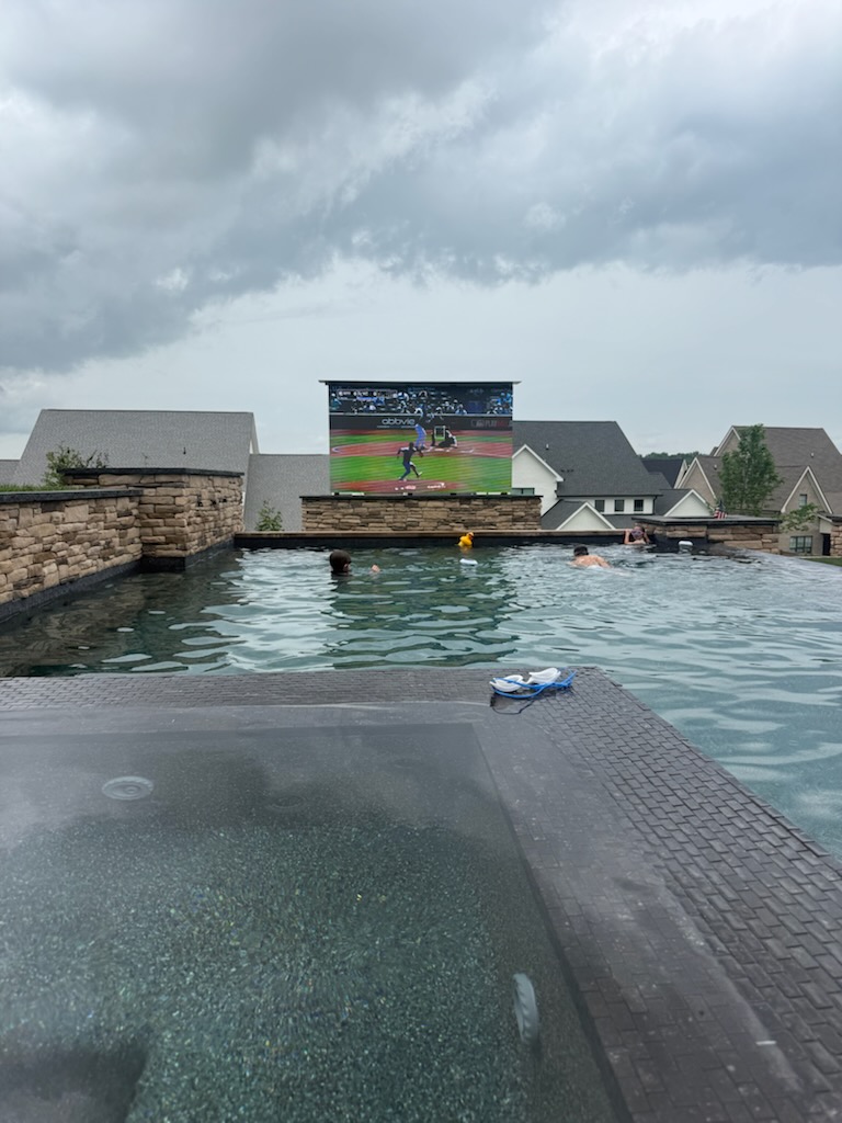 After: fully installed 158-inch Rise display raised into viewing position over the pool deck