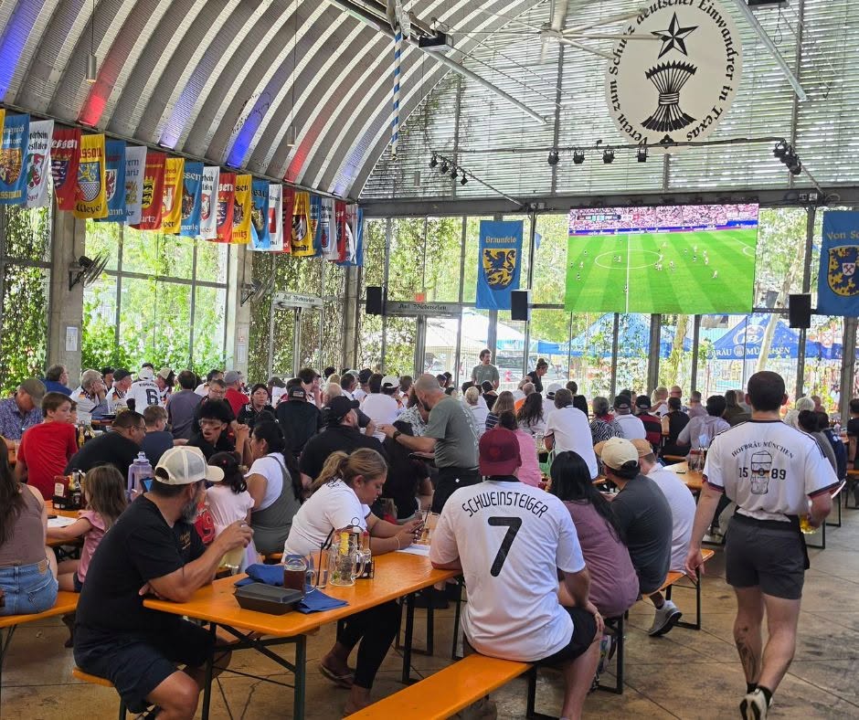 Giant YOLO outdoor screen glowing over a packed restaurant patio during a watch party