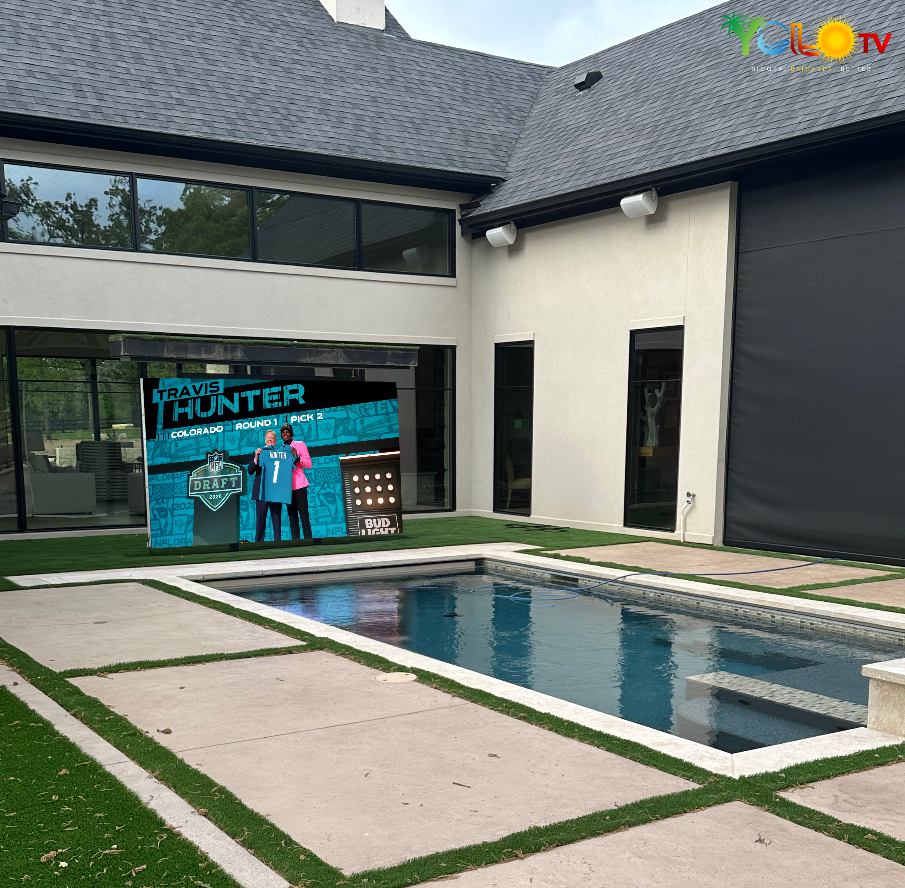 138-inch YOLO TV wall-mounted outdoors on a finished patio, showing the scale of a professionally installed large-format display