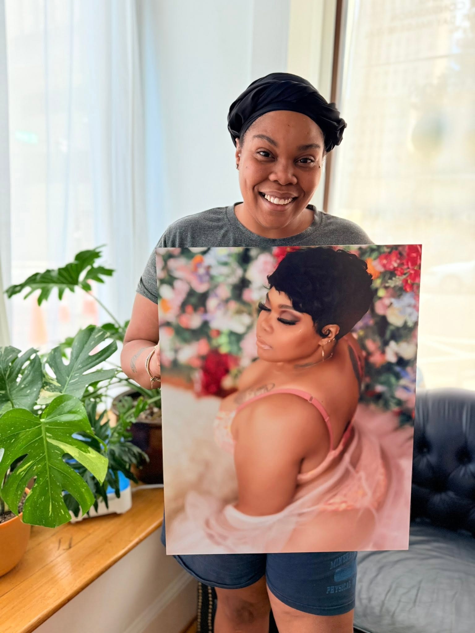 A Goddess client holding her metal print