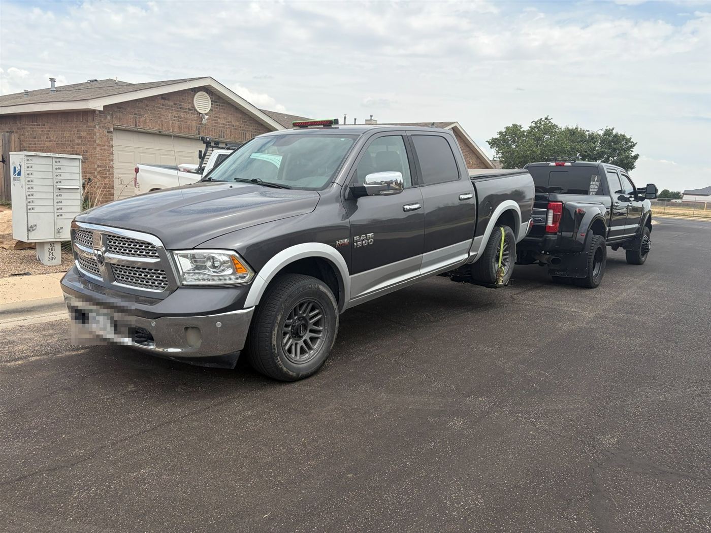 Gray Ram pickup on a wheel-lift tow