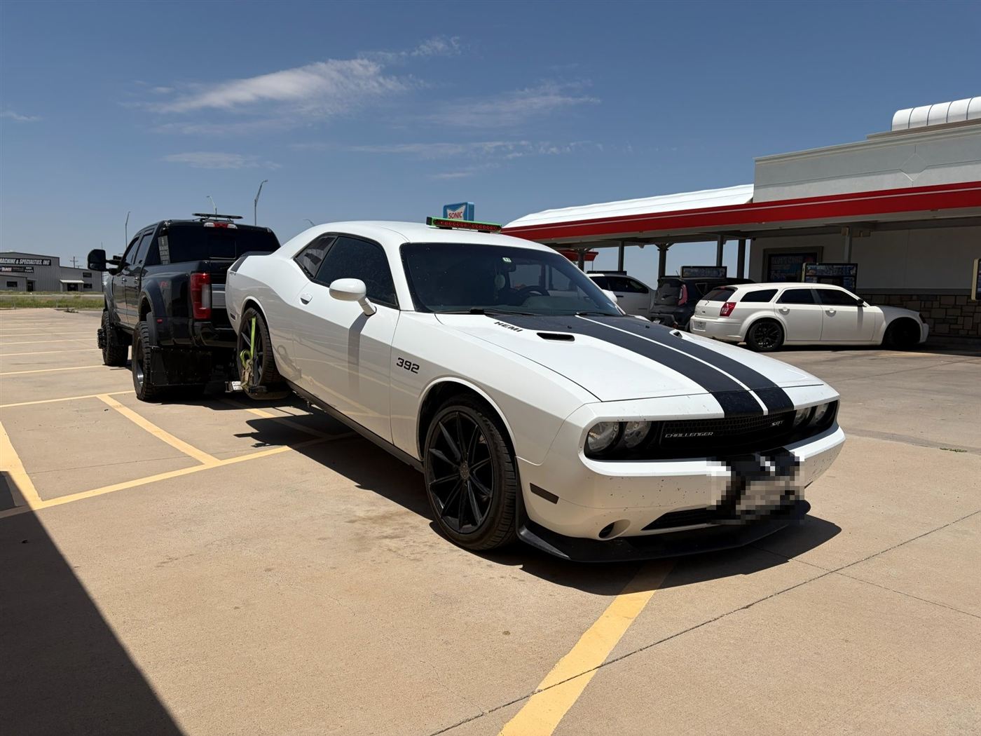 White Dodge Challenger being towed