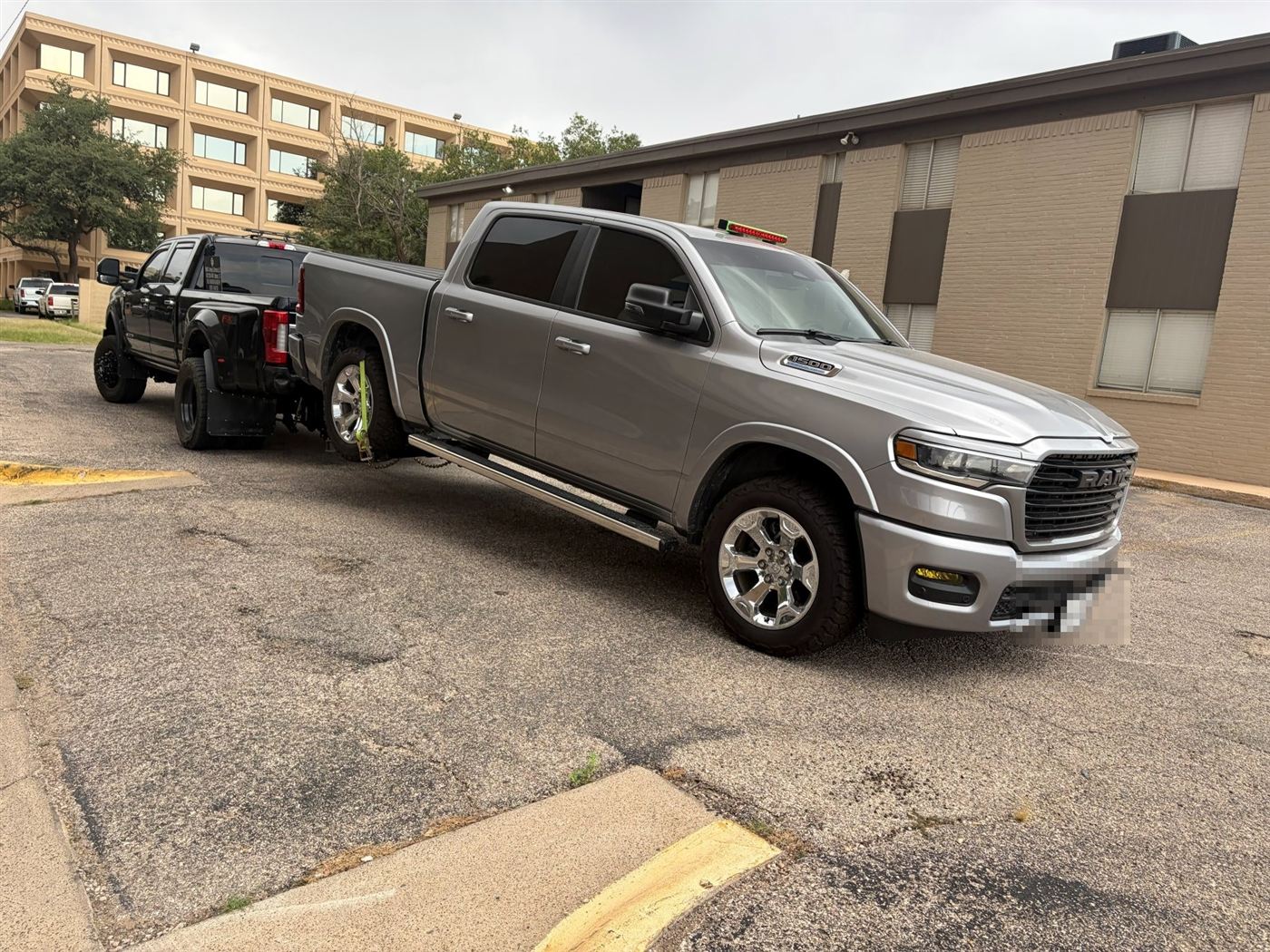 Silver Ram pickup being towed