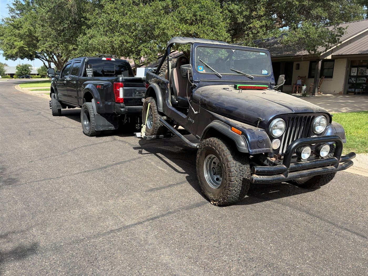 Classic black Jeep CJ being towed