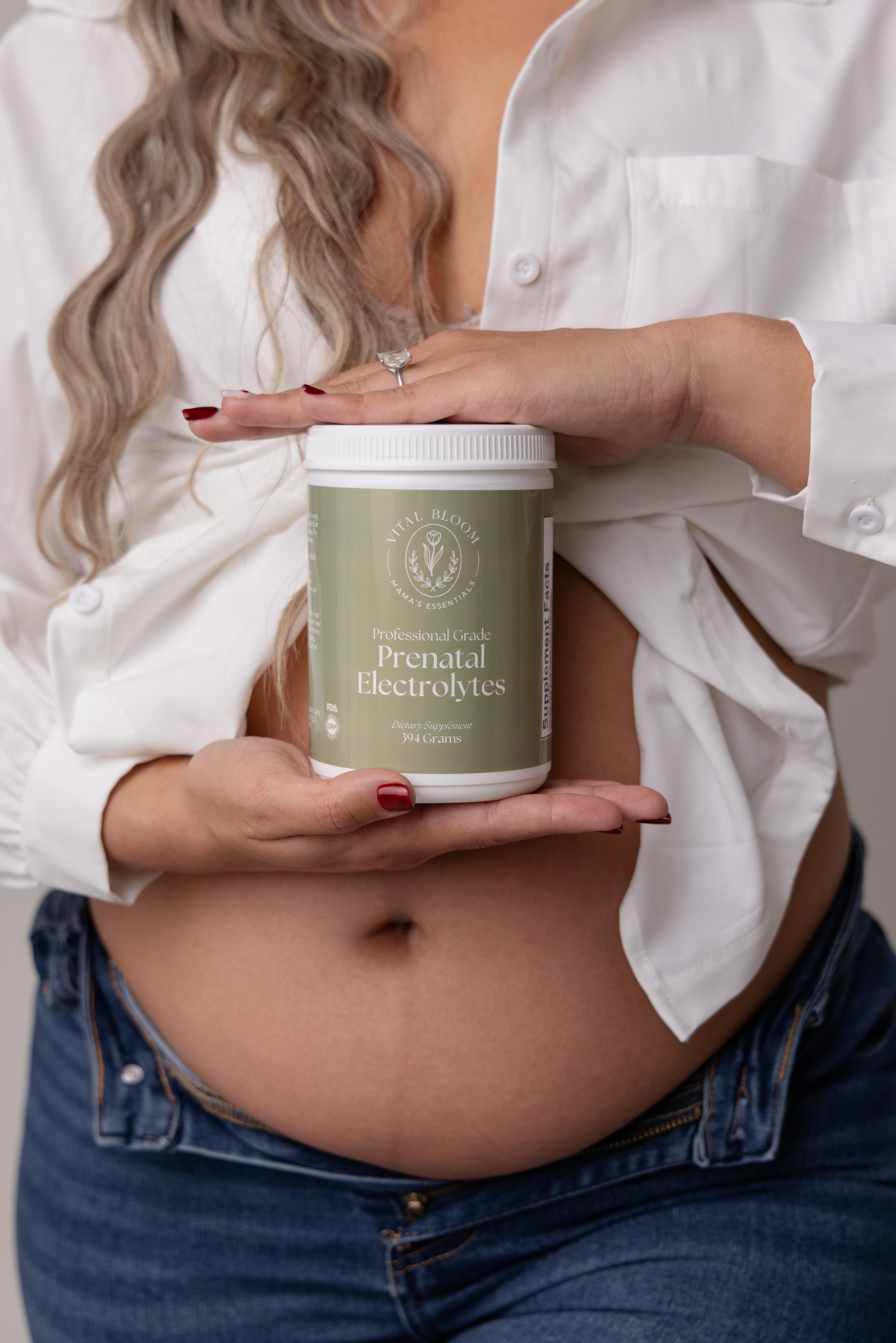 Vital Bloom Prenatal Electrolytes powder canister open with scoop and powder on a cream surface