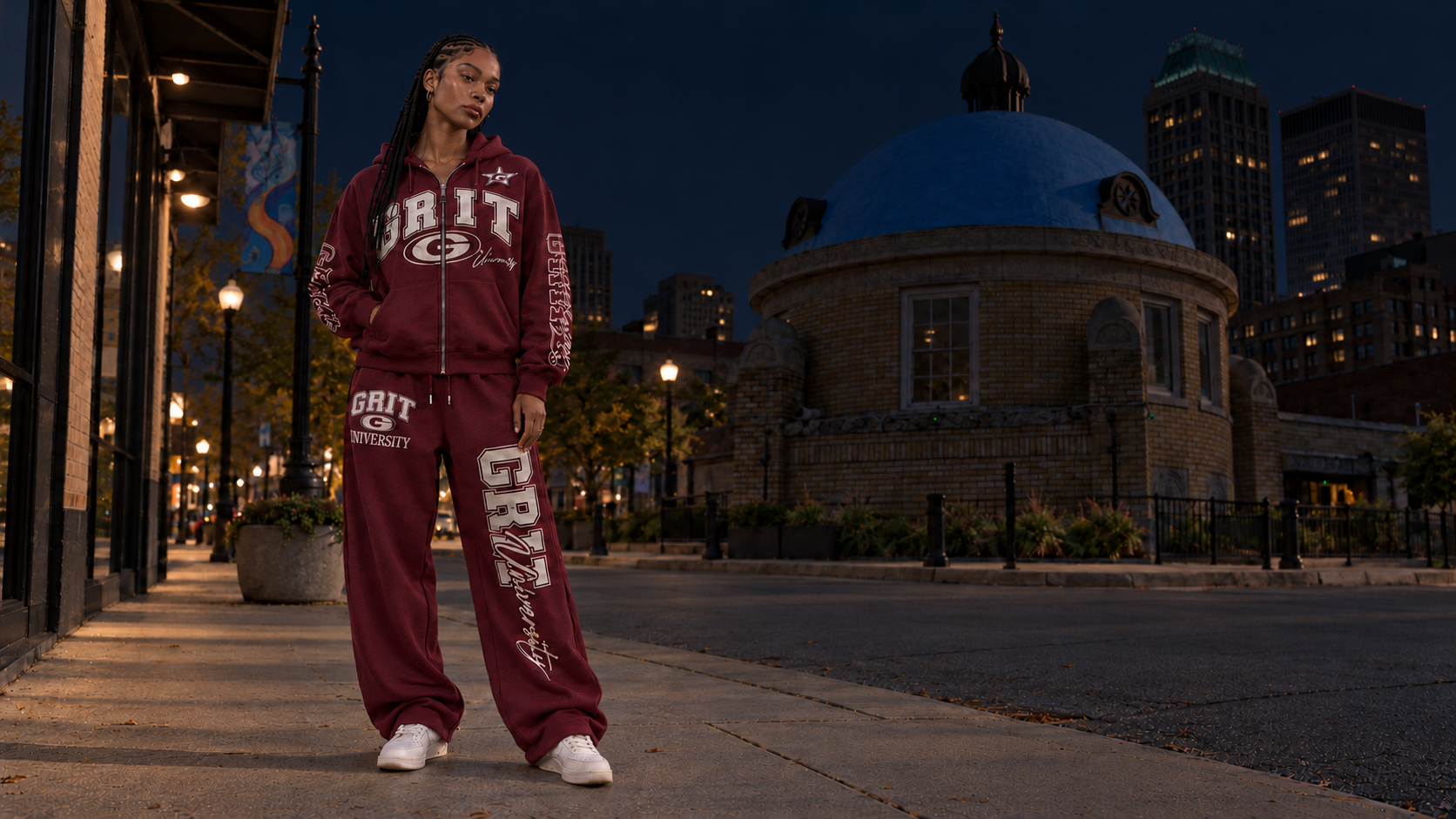 A woman wearing the maroon GRIT University collection at the Tulsa Blue Dome at night