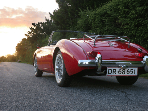 Classic red convertible car on scenic road