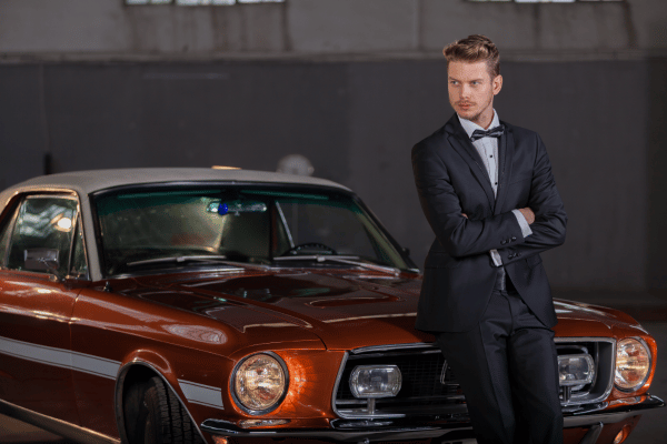 Man in suit with classic muscle car