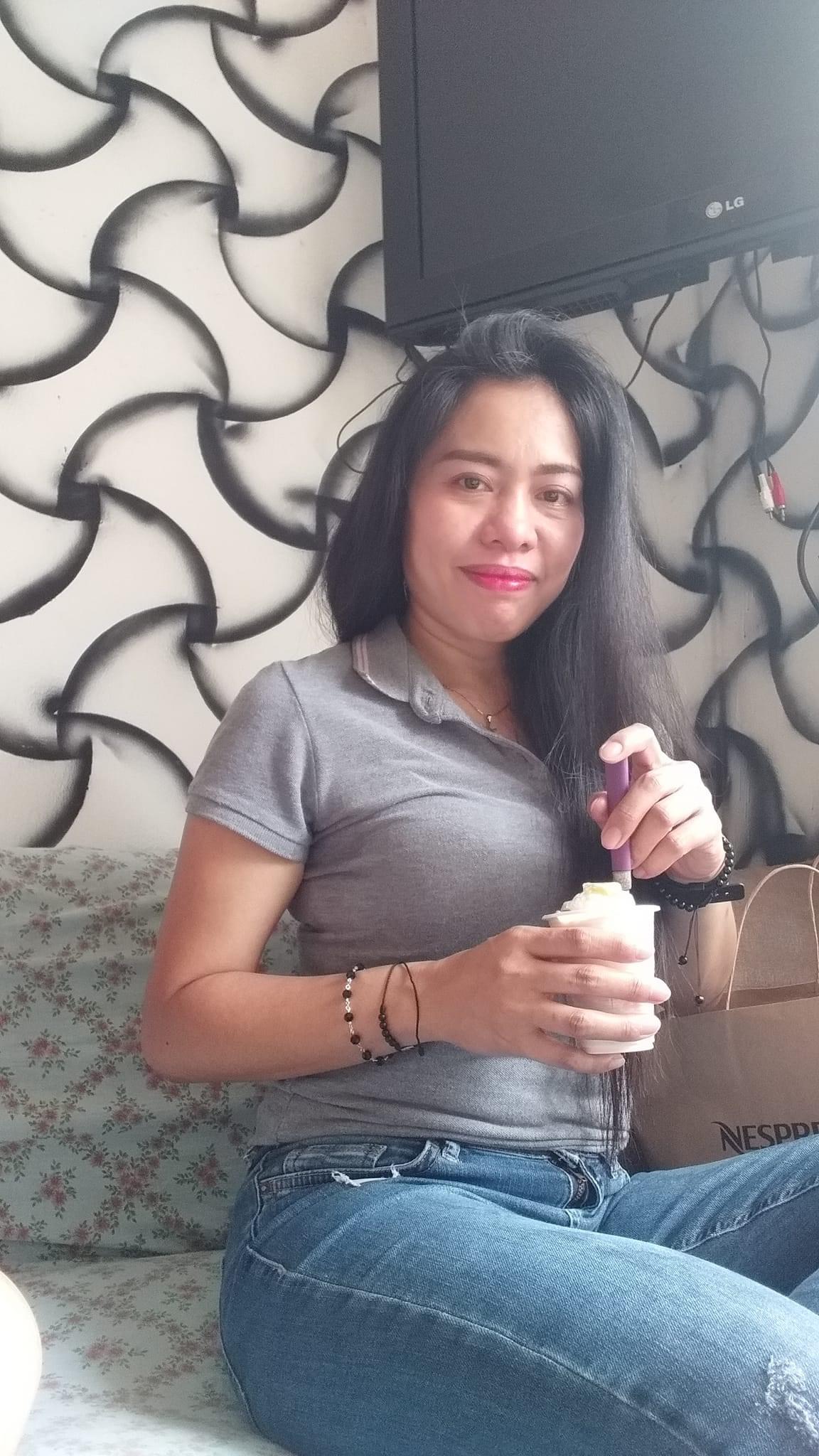 Wennzel Macoy sitting on a sofa with a cup in her hand
