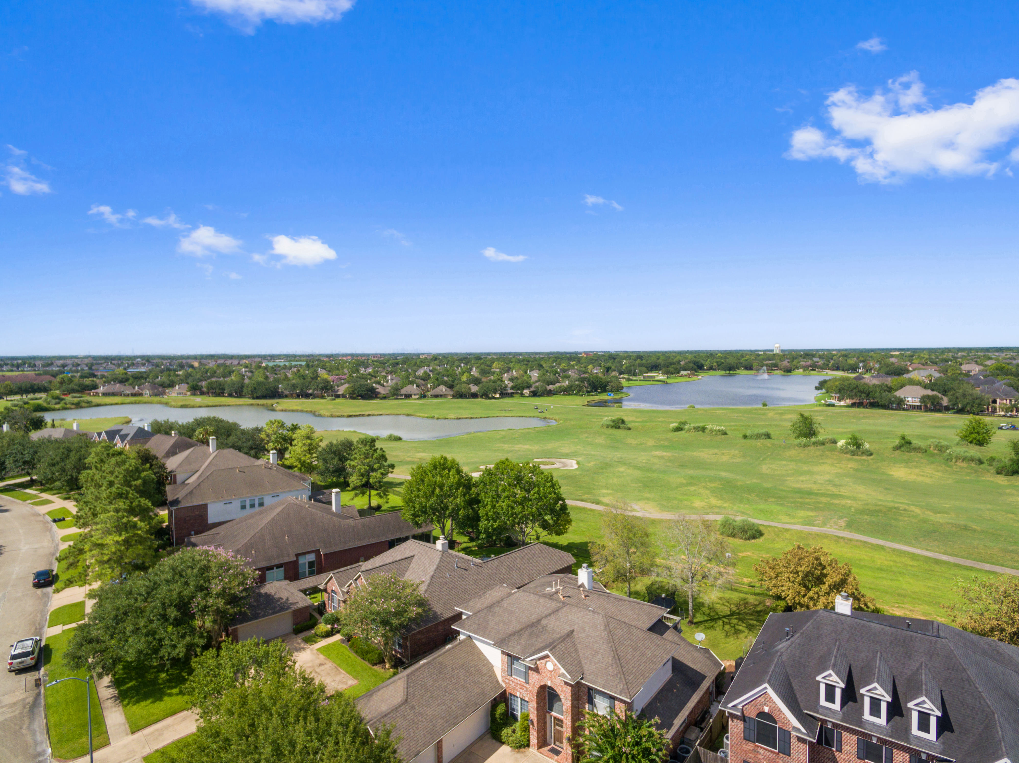 Aerial view of Silverlake in Pearland, Texas, showing brick homes alongside golf course fairways, lakes, and mature trees.