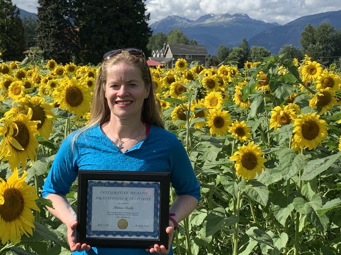Melissa Deally in a Field of Sunflowers with IHP Certificate