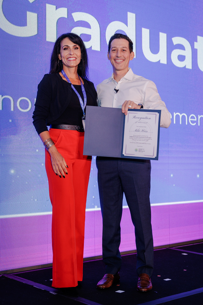 Dr. Stephen Cabral Presenting Certificate of Achievement at the Reimagining Health Summit to a Graduate