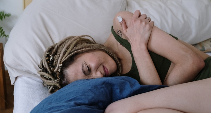 Chronically Ill Woman Laying in Bed in Pain Chronically Ill Woman Laying in Bed in Pain