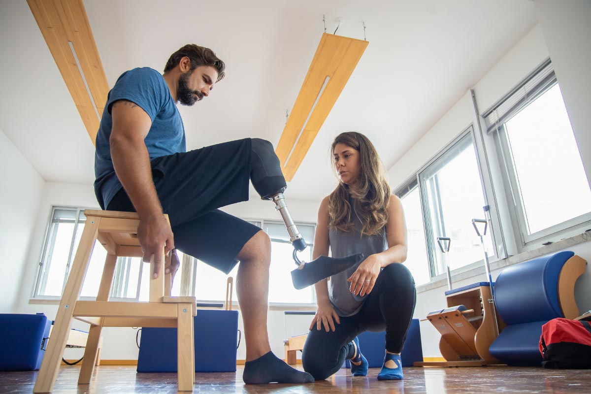 Patient with a prosthetic leg working with a therapist during a rehabilitation session.
