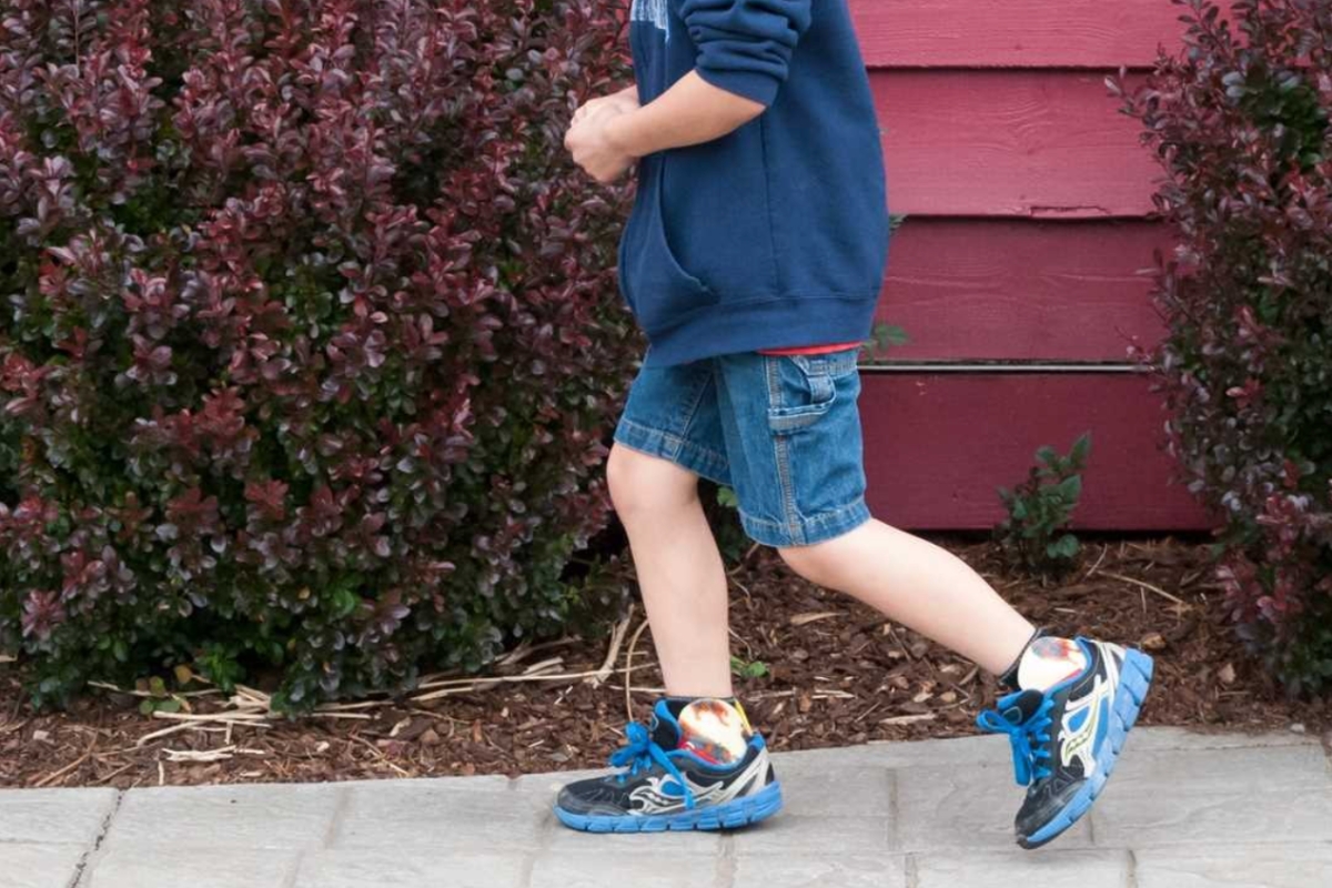 Child walking outdoors wearing orthotic devices, showing the movement possibilities that exist with supportive orthotic braces.