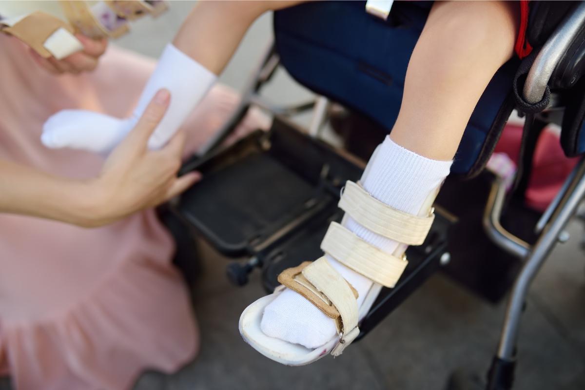 Clinician fitting a custom orthotic device on a child’s leg, demonstrating proper adjustment and comfort.