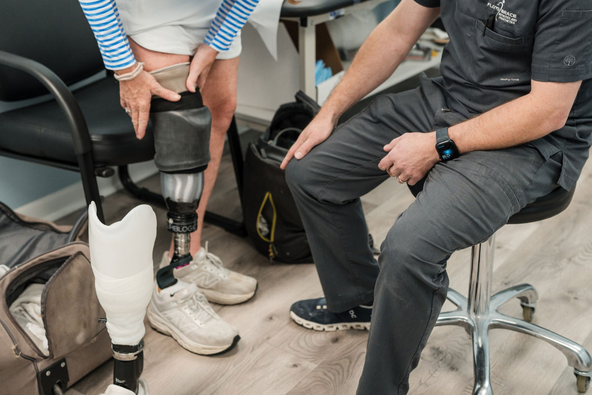 Prosthetist discussing prosthetic socket fit with a patient during a follow-up appointment