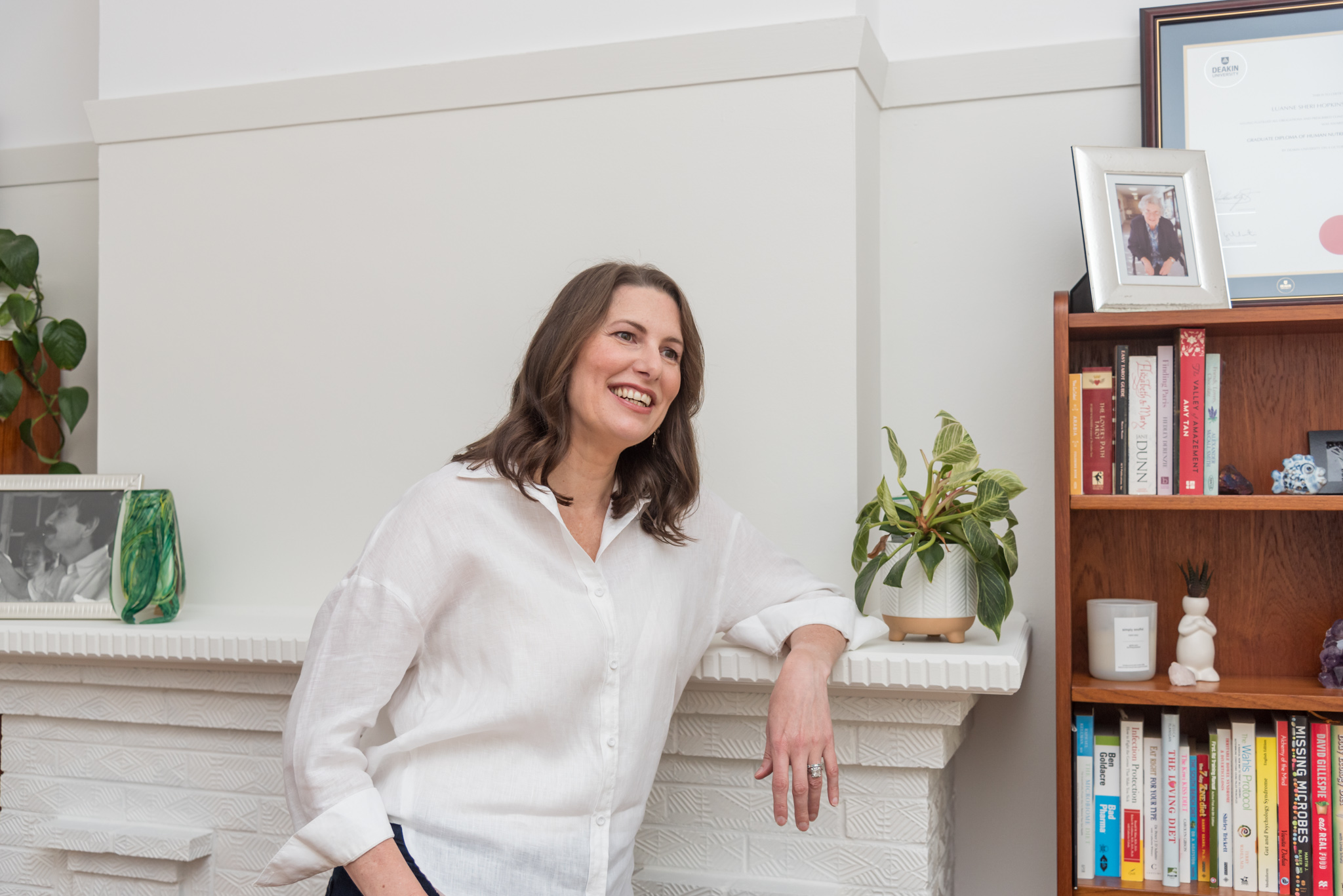 Luanne Hopkinson relaxed at home, bookshelves visible behind her