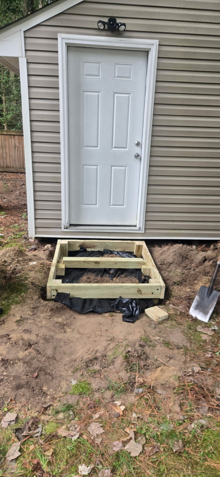 Black ground sheet laid underneath the shed step frame before the decking goes on