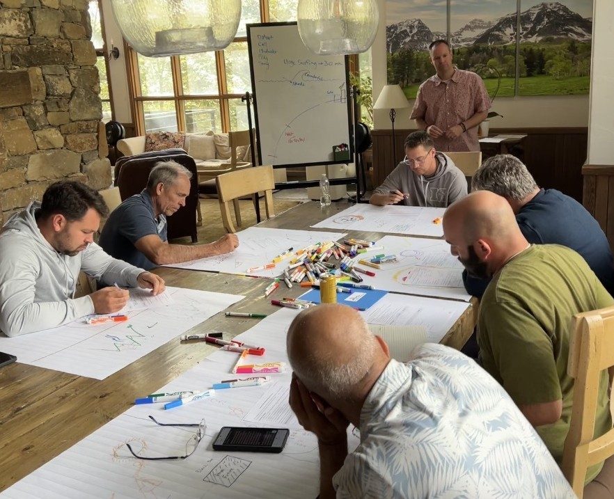 Participants working at a long table during a session