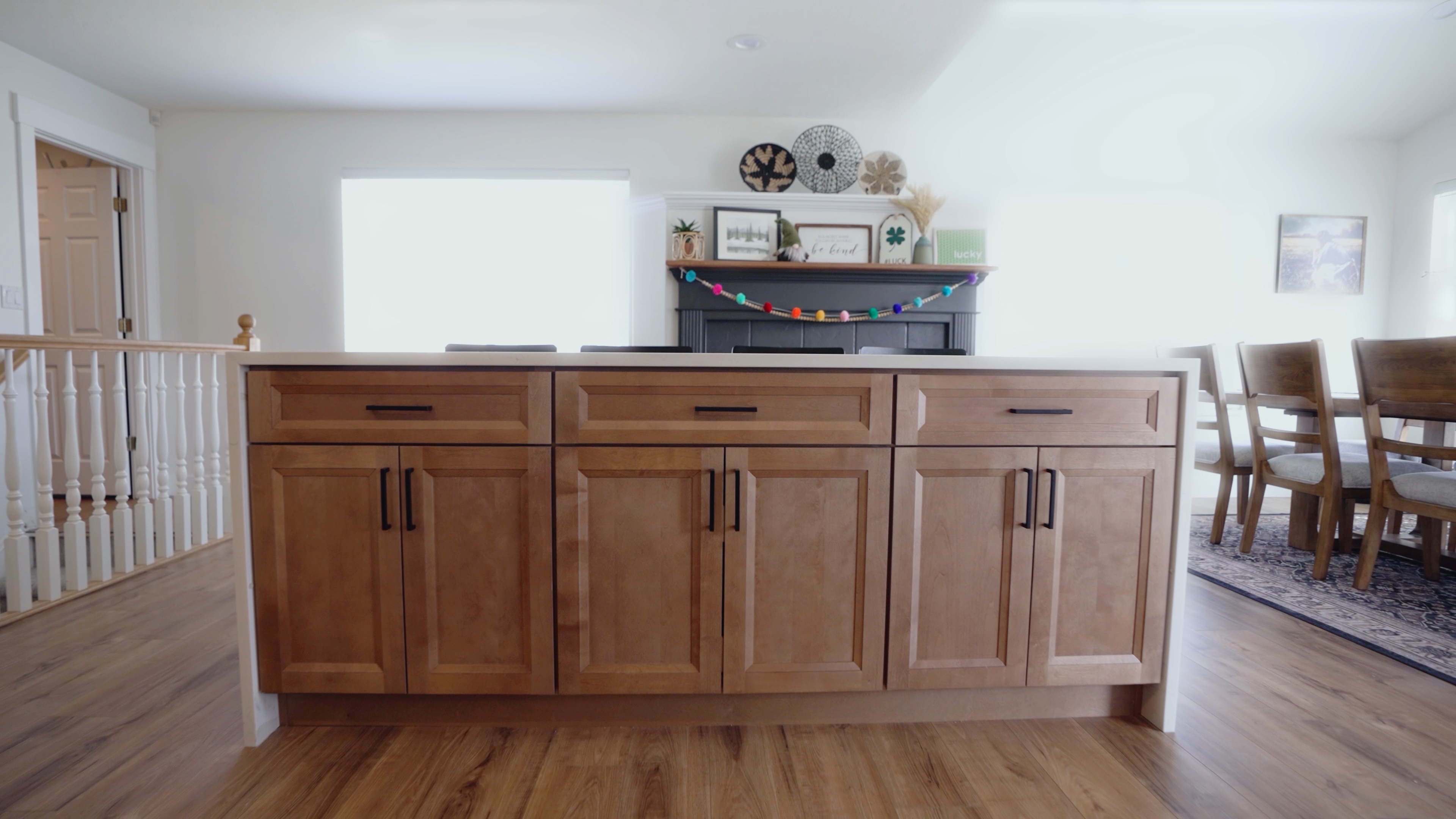Stained maple kitchen island cabinetry with black bar pulls opening onto a dining room in Lehi, Utah