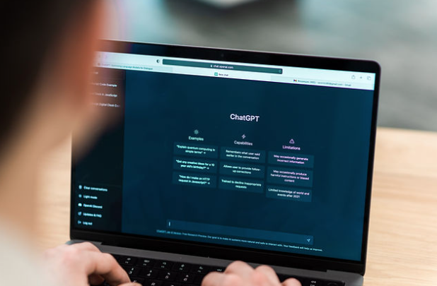 Person using ChatGPT on a laptop to generate and refine AI-assisted content, illustrating the content creation stage of a strategic AI workflow.