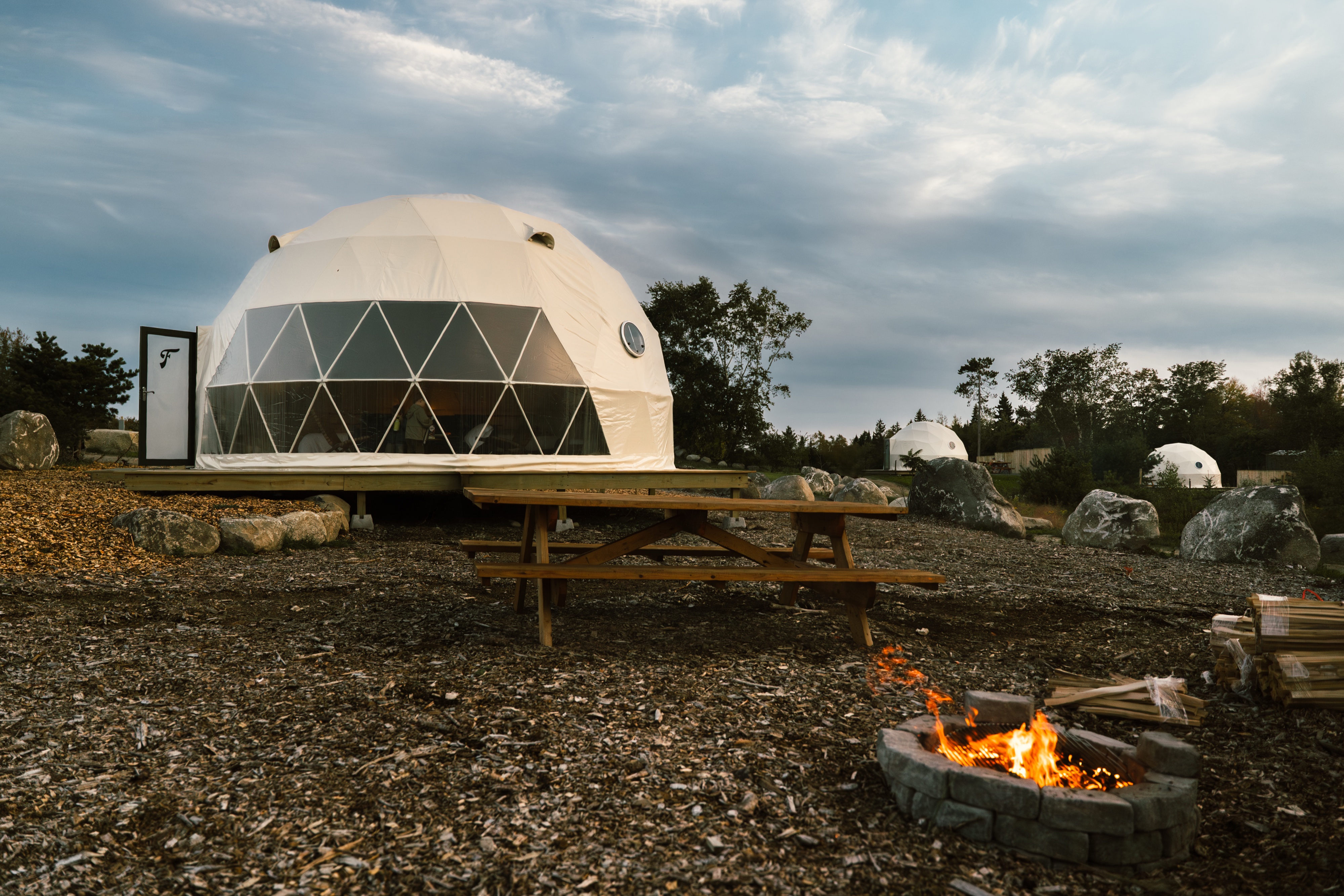 Dome at dusk with a lit fire pit